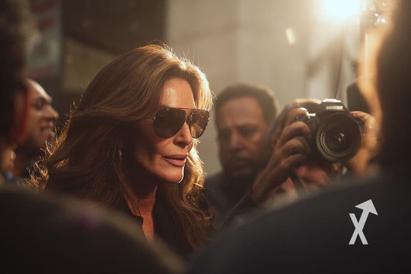 Caitlyn Jenner avec des lunettes de soleil entouré de papparazzi
